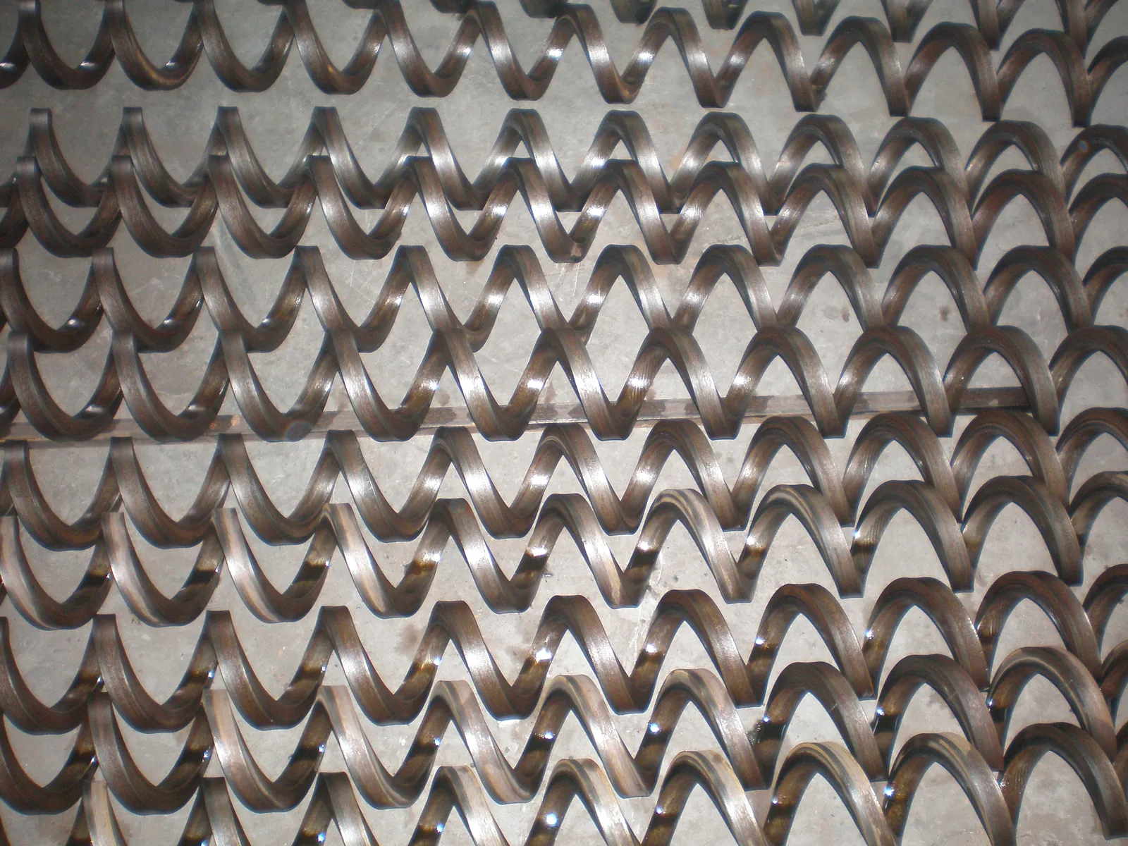 Flexible auger coils showing their square-section bar profile